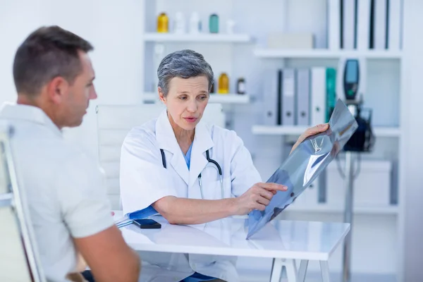 Ärztin zeigt ihrem Patienten Röntgenbilder — Stockfoto