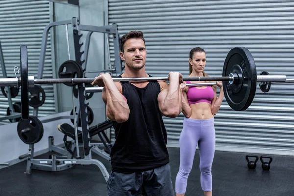 Couple musculaire soulevant le poids ensemble — Photo