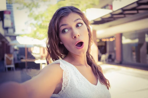 Retrato de una mujer sonriente apuntando a la ventana — Foto de Stock