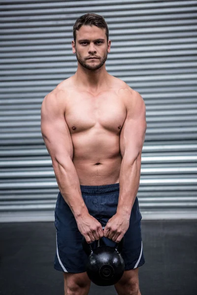 Портрет мускулистого человека, поднимающего гири — стоковое фото