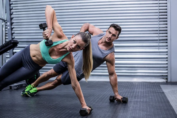 Casal muscular fazendo prancha lateral — Fotografia de Stock