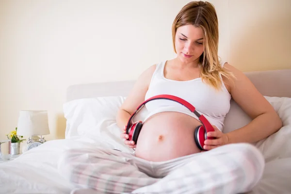 Hamile kadın yatakta rahatlatıcı — Stok fotoğraf