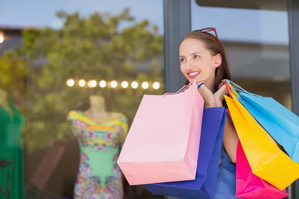 Mutlu bir kadın alışveriş çantaları taşırken — Stok fotoğraf