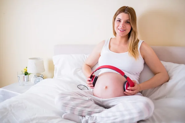 Gravid kvinna avkopplande på sängen — Stockfoto