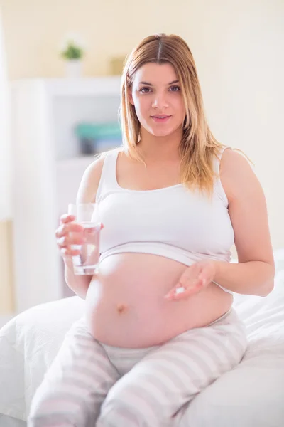 Terhes nő ül az ágyon — Stock Fotó