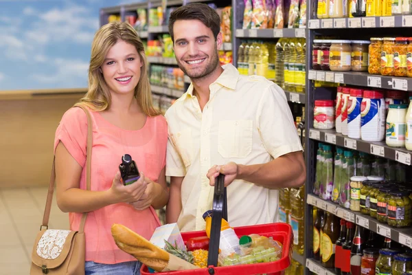 Retrato de casal sorridente brilhante comprando produtos alimentares usando sho — Fotografia de Stock