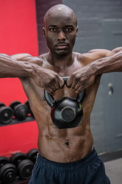 Portrait of muscular man lifting a kettlebell — Stock Photo, Image