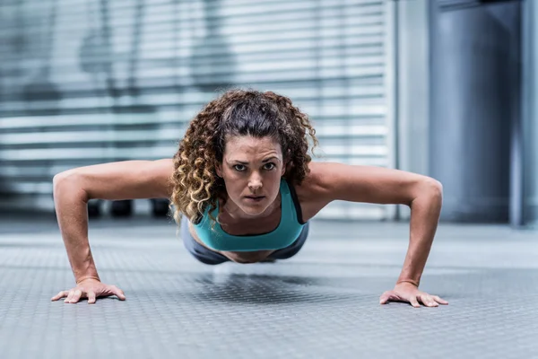 Mulher muscular fazendo flexões — Fotografia de Stock