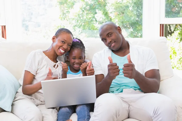 Família feliz no sofá com laptop — Fotografia de Stock