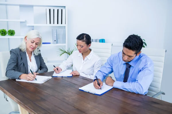 Gente de negocios escribiendo en portapapeles — Foto de Stock