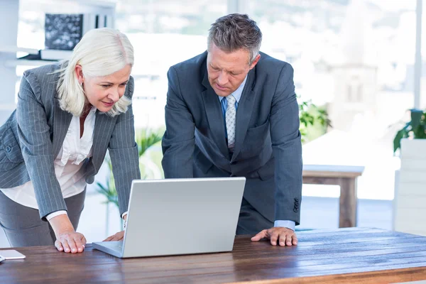 Serious business people looking at laptop — Stock Photo, Image