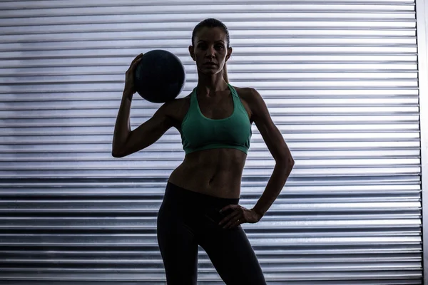 Mujer muscular sosteniendo una pelota de medicina —  Fotos de Stock