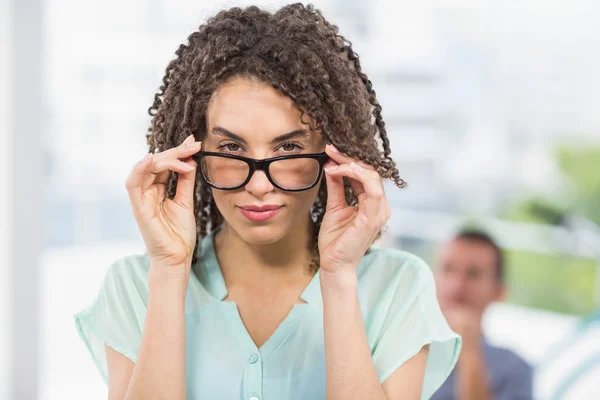 Bastante mujer de negocios inclinando sus gafas de lectura — Foto de Stock