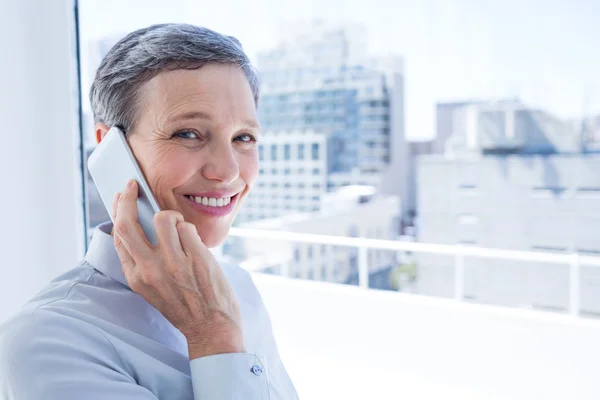 Businesswoman looking at camera while on the phone — Stock Photo, Image