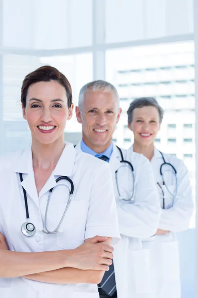 Tres colegas médicos sonrientes con los brazos cruzados — Foto de Stock