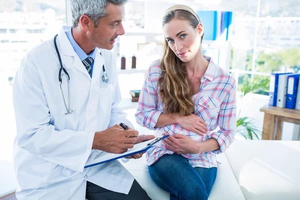 Seduto donna incinta parlando con il suo medico — Foto Stock