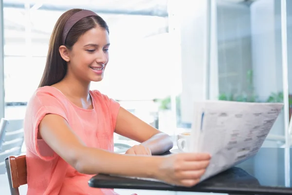 Счастливая женщина, читающая газету — стоковое фото