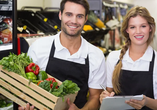 Colegas sosteniendo una caja con verduras frescas — Foto de Stock