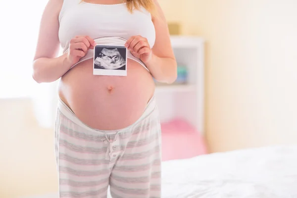 Těhotná žena ukazující ultrazvukové vyšetření — Stock fotografie