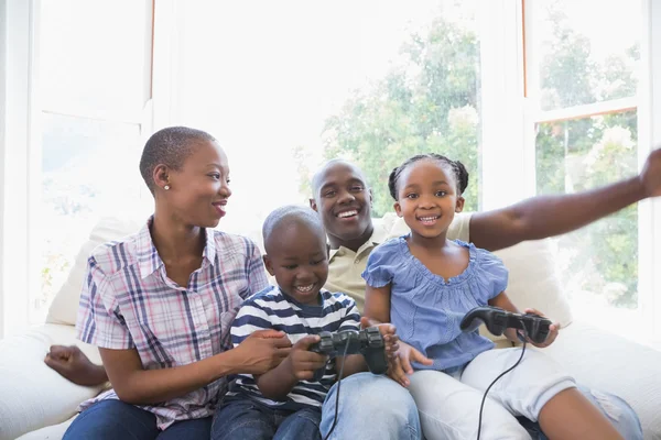 Счастливая улыбающаяся семья, играющая вместе в видеоигры — стоковое фото