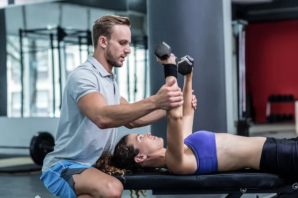 Een gespierde vrouw opheffing halters — Stockfoto