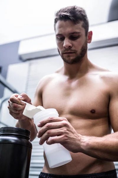 Muscular man making protein cocktail — Stock Photo, Image