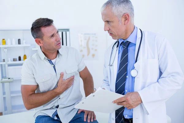 Серьезный врач разговаривает со своим пациентом — стоковое фото