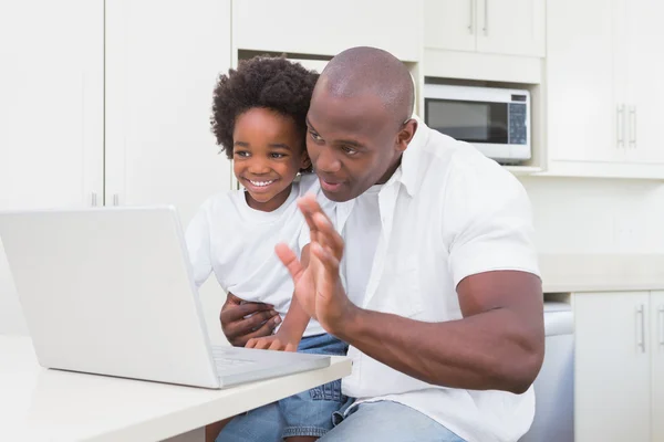 Pai e filho usando laptop no sofá — Fotografia de Stock