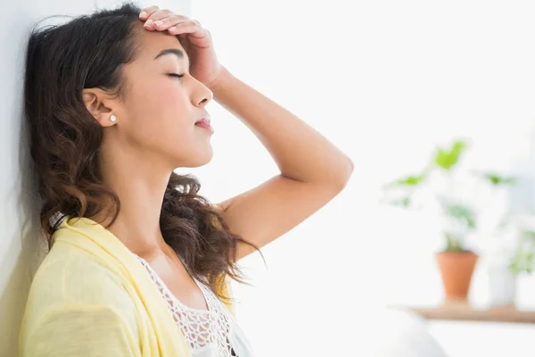 Young thinking businesswoman leaning against a wall — Stock Photo, Image