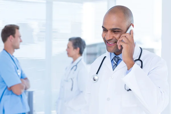 Улыбающийся доктор разговаривает по телефону — стоковое фото