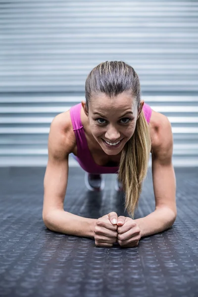 Een gespierde vrouw op een plank positie — Stockfoto