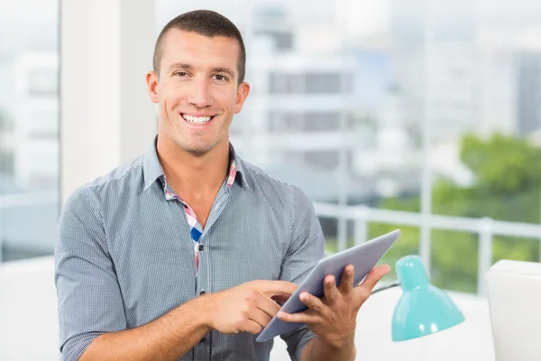 Empresário sorridente apontando para seu tablet — Fotografia de Stock