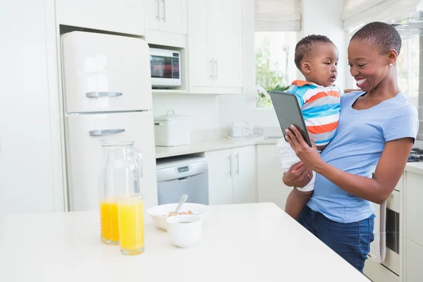 Szczęśliwy uśmiechający się matka z hisbabyboy za pomocą cyfrowego tabletu — Zdjęcie stockowe