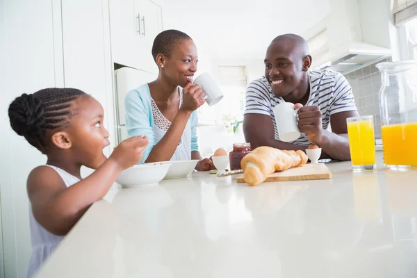 Família feliz sentado e tomando café da manhã — Fotografia de Stock