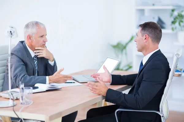 Two serious businessmen speaking and working