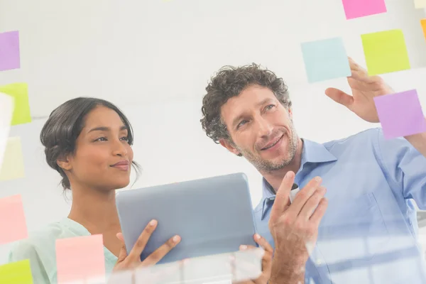 Puzzled business team looking post its on the wall — Stock Photo, Image
