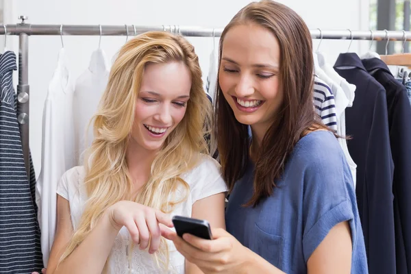 Amigos sorridentes procurando um smartphone — Fotografia de Stock