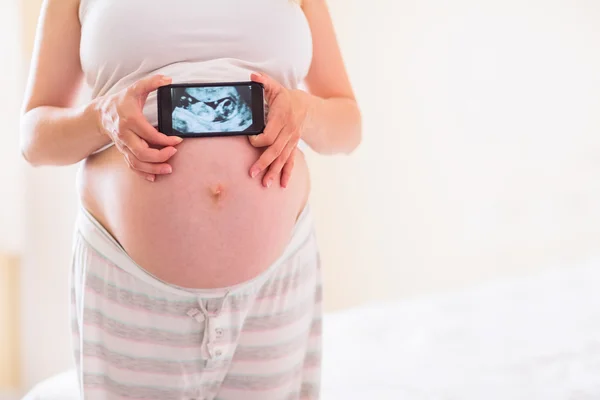 Mujer embarazada mostrando ecografías — Foto de Stock