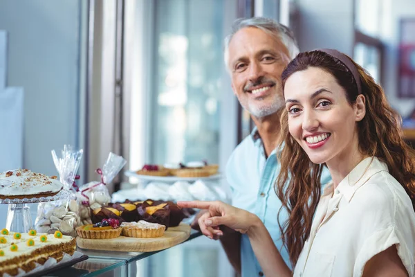 Pareja feliz señalando pasteles —  Fotos de Stock