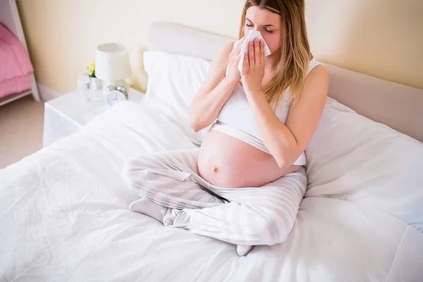妊娠中の女性が彼女の鼻を吹く — ストック写真