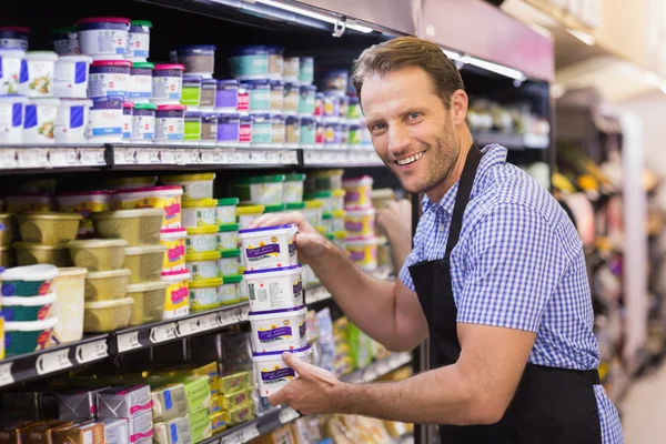 Retrato de un guapo sonriente sosteniendo un producto lácteo — Foto de Stock