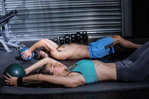 Casal fazendo crunch abdominal — Fotografia de Stock