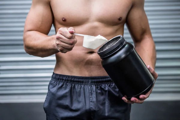 Muscular man making protein cocktail — Stock Photo, Image