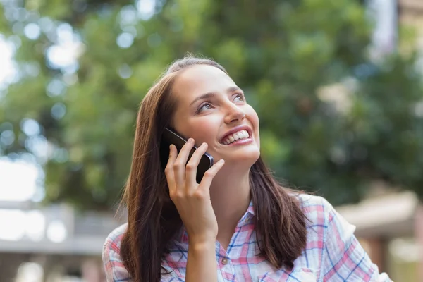 Dość brunetka o telefon i patrząc od hotelu — Zdjęcie stockowe