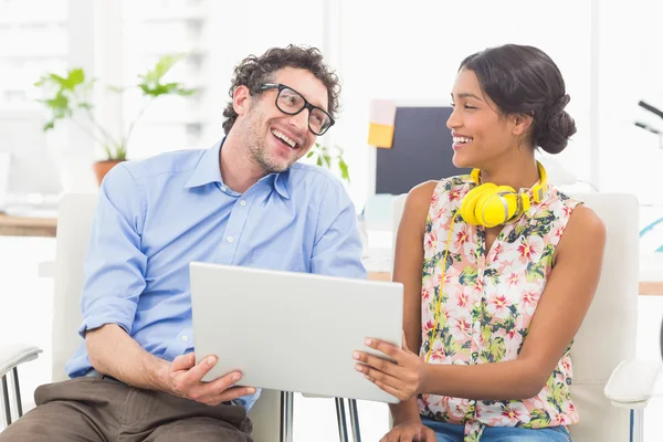 Casual business partners holding laptop — Stock Photo, Image