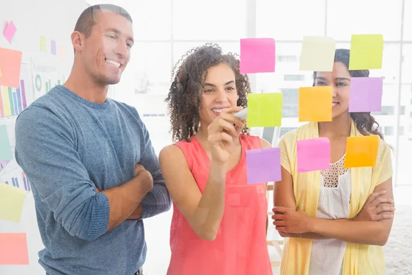 Collaboratori sorridenti che scrivono su appunti adesivi — Foto Stock