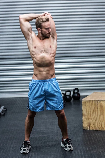 Homem muscular fazendo alongamentos de braço — Fotografia de Stock