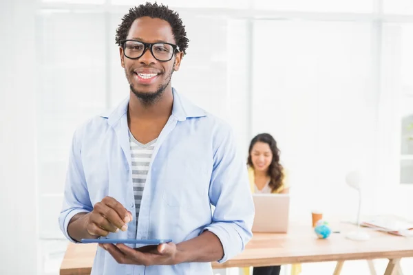 Smiling man posing in front of his colleague with tablet compute — Stock Photo, Image