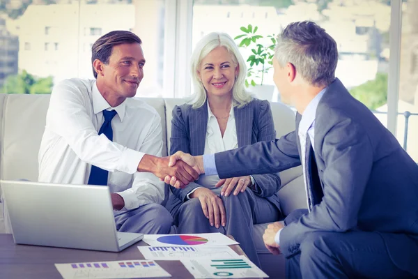 Business people shake hands on couch — Stock Photo, Image