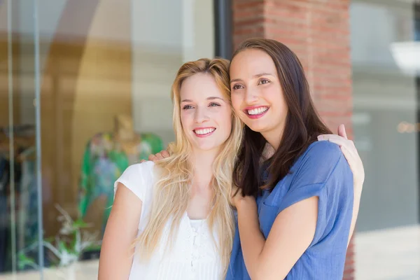 Lächelnde Freundinnen mit herumliegenden Armen — Stockfoto